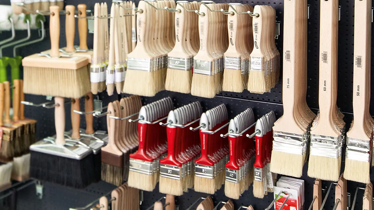 Brooms and paint brushes by Nölle Profi Brush on a shop display wall