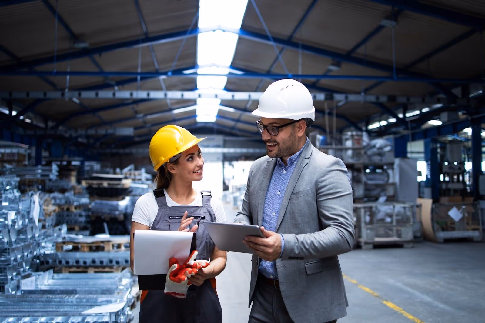 A man and a woman working on DIN EN 10204 Certification in an industry.